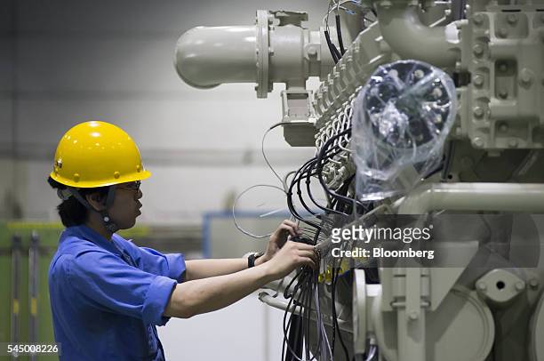 Worker assembles an engine at the Mitsubishi Heavy Industries Engine & Turbocharger Ltd. Plant in Sagamihara, Kanagawa Prefecture, Japan, on Monday,...