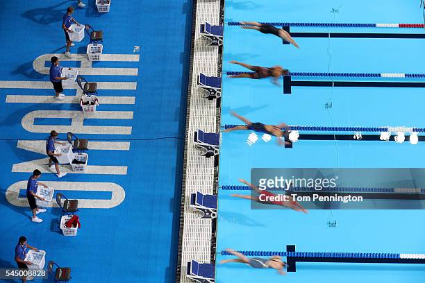 Swimmers dive in to compete in the first heat of the Women's 50 Meter Freestyle during Day Seven of the 2016 U.S. Olympic Team Swimming Trials at...