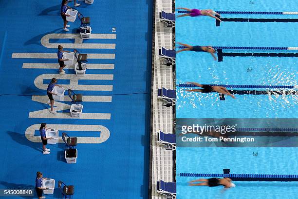 Swimmers dive in to compete in the second heat of the Women's 50 Meter Freestyle during Day Seven of the 2016 U.S. Olympic Team Swimming Trials at...