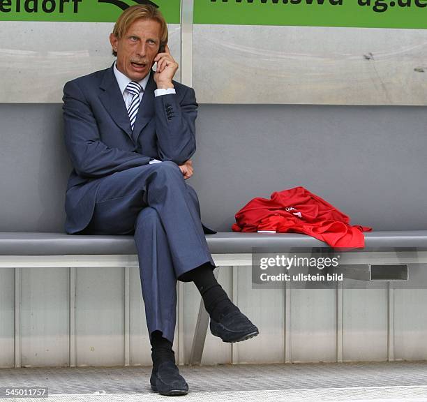 Daum, Christoph - Football, Coach, 1. FC Koeln, Germany - sitting on the substitutes' bench, using his mobile phone