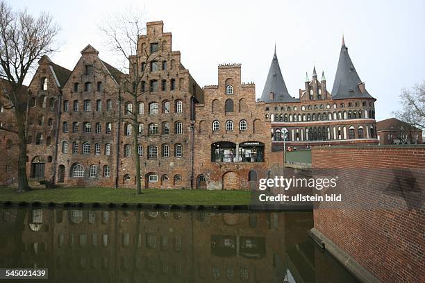 Germany - Schleswig-Holstein - Luebeck: Historic storehouses at"Obertrave" river with "Holstentor"in the background.