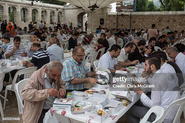 Turkish Muslims enjoy free meals distributed after attending Eid al Fitr prayers as they mark the first day of the Eid al-Fitr at Fatih Sultan Mosque...