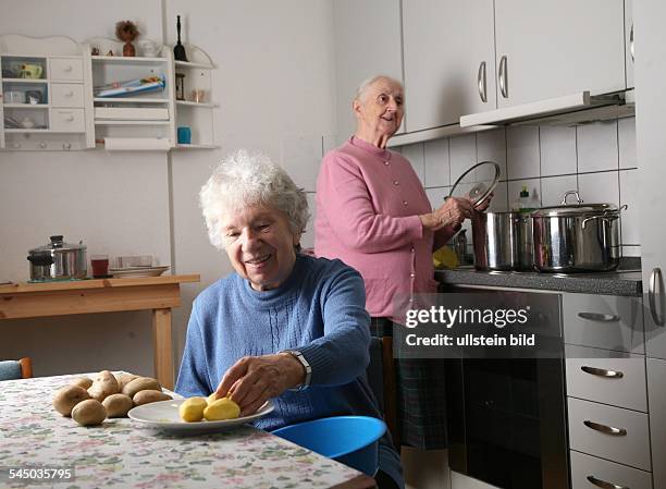 Deutschland, Brandenburg, Potsdam, Senioren-WG, Seniorinnen beim gemeinsamen Kochen in der Kueche-