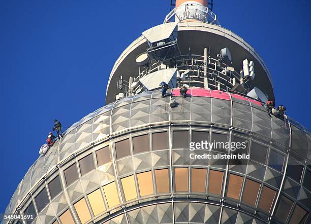 Deutschland, Berlin Mitte, Fernsehturm am Alexanderplatz - Industriekletterer befestigen einzelne Folien, die als Symbol für die...