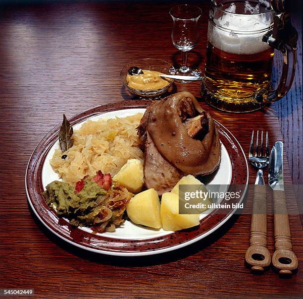 Eisbein mit Erbspürree, Sauerkraut undSalzkartoffeln, daneben ein Glas Bier- 1996