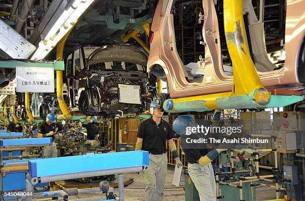 Workers assemble vehicles at the production line at the Mitsubishi Motors Mizushima Plant on July 4, 2016 in Kurashiki, Okayama, Japan. The fuel...