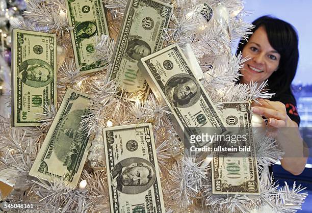 Synthetic Christmas tree decorated with dollar banknotes