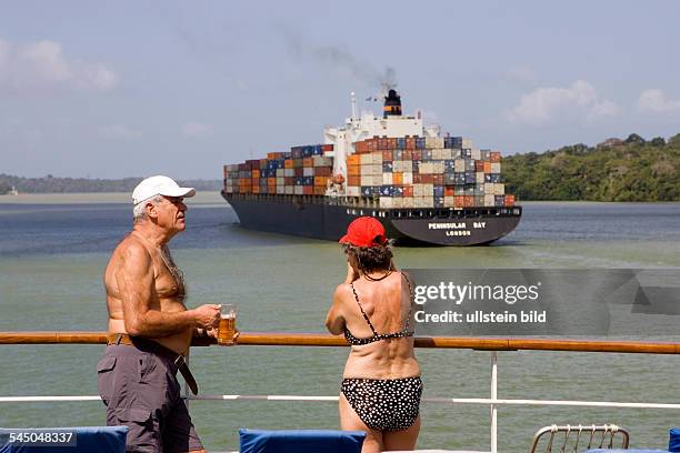 Panama - : Cruise ship MS ASTOR passing the Panama Canal. Party to celebrate the passage. Passengers with a glass of beer standing at the taffrail....