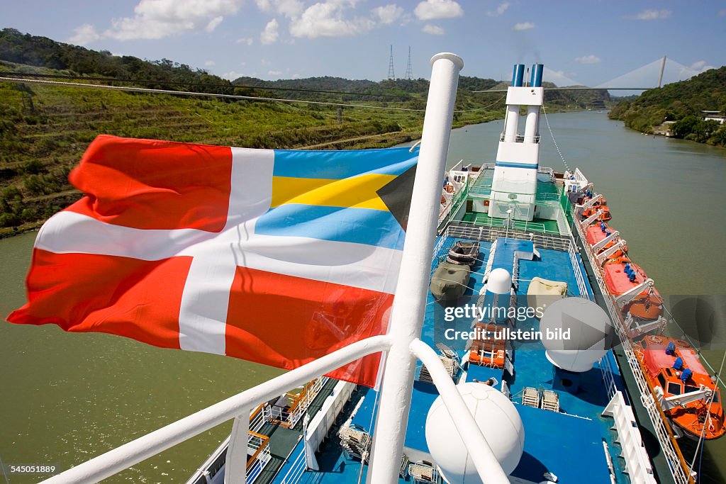 Panama - : Cruise ship MS ASTOR passing the Panama Canal heading for the Pacific Ocean at the most narrow part of the passage, called the Gaillard cut. Ship is sailing under the merchant flag of the Bahamas.