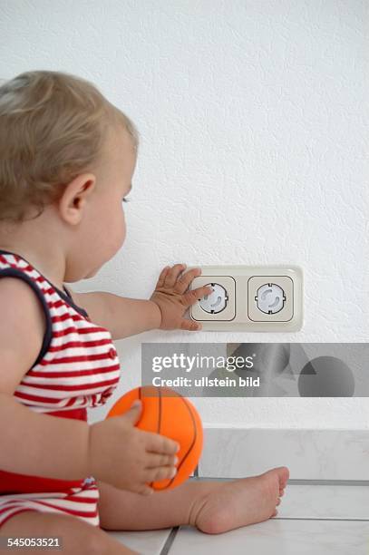 Child is playing with a child-proof socket -