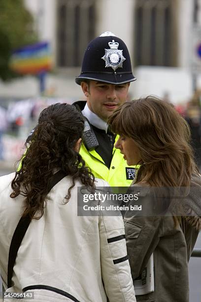 England, UK, London - Bobby, Polizist, gibt Touristinnen Auskunft