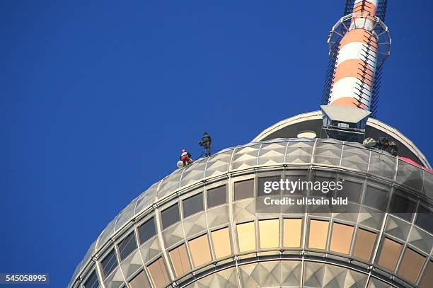 Deutschland, Berlin Mitte, Fernsehturm am Alexanderplatz - Industriekletterer befestigen einzelne Folien, die als Symbol für die...