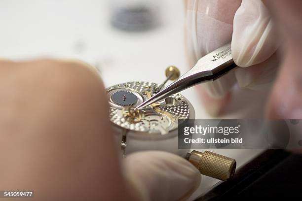Deutschland, Sachsen, Glashütte - Uhrenherstellung im Werk des Uhrenherstellers A. Lange & Söhne, die Zahnräder werden montiert