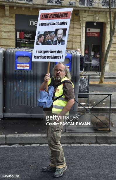 Man holds a sign reading 'State of emergency, troublemakers, assign them outside their public duties' during a demonstration against proposed...