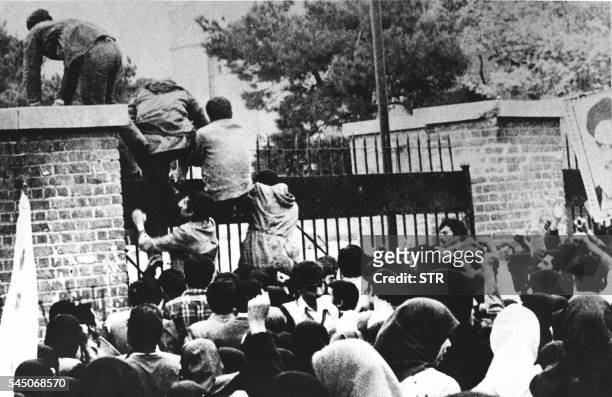 Iranian students climb over the wall of the US embassy in Tehran 04 November 1979. Twenty years later, 04 November 1999, the former embassy building...
