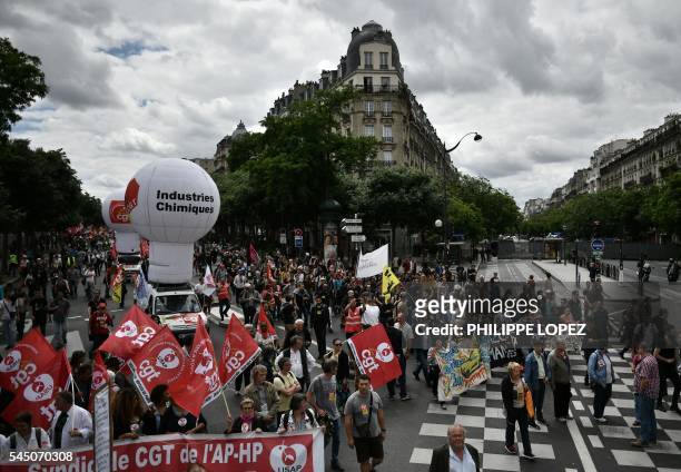 People hold banners and flags during a demonstration against proposed government labour and employment law reforms on July 5, 2016 Paris. - The...