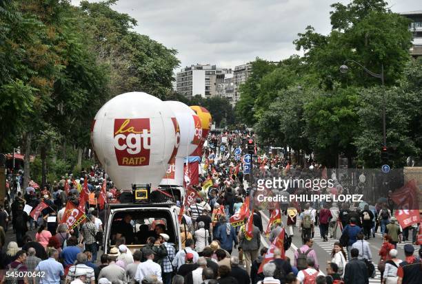 People hold flags of French trade union CGT during a demonstration against proposed government labour and employment law reforms on July 5, 2016...