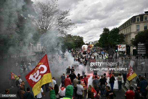 People hold flags of French trade union CGT and flares during a demonstration against proposed government labour and employment law reforms on July...