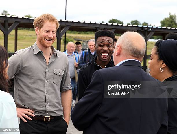 Britain's Prince Harry speaks to the team as he visits The Blair Project at Three Sisters Racing Circuit in Wigan, north west England on July 5,...