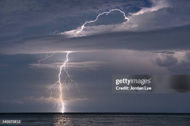 lightning strike into the sea - lightning strike imagens e fotografias de stock