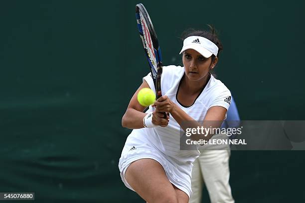 India's Sania Mirza returns to Britain's Neal Skupski and Anna Smith during a mixed doubles second round match on the ninth day of the 2016 Wimbledon...