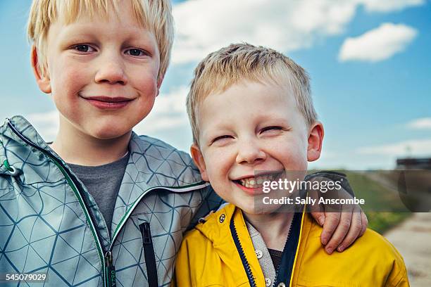 two happy smiling little boys outdoors - brothers boys cuddle stock pictures, royalty-free photos & images