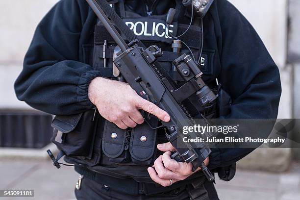 an armed police officer in london, england - cultura británica fotografías e imágenes de stock