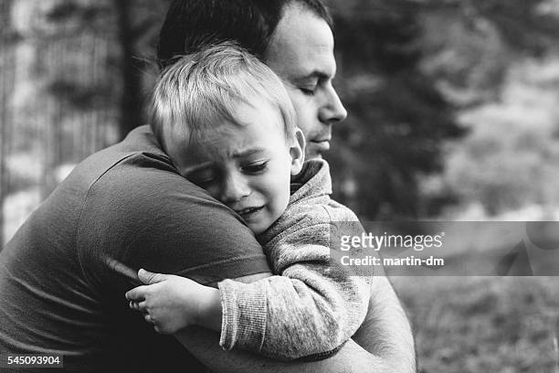 father hugging his crying son - children divorce bildbanksfoton och bilder