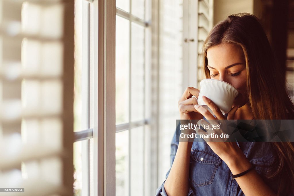 Woman drinking coffee early in the morning