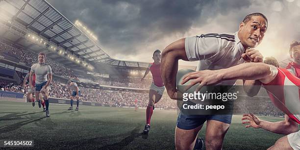 rugby-spieler läuft mit ball während angepackt während des spiels - rugby sport stock-fotos und bilder