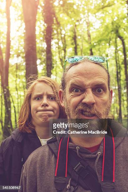 father and son pulling faces... - catherine macbride stock pictures, royalty-free photos & images
