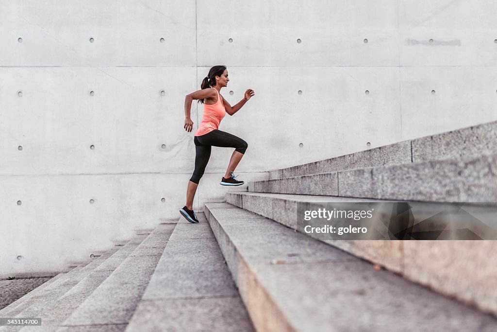Latina deporte mujer corriendo al aire libre con escalera en Berlín