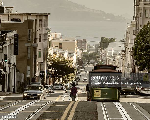 woman & cable car silhouetted in intersection. - nob hill stock pictures, royalty-free photos & images