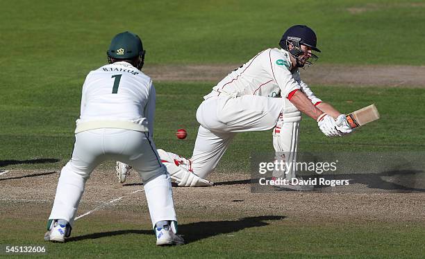 Tom Smith of Lancashire sweeps the ball for four runs during the Specsavers County Championship division one match between Nottinghamshire and...