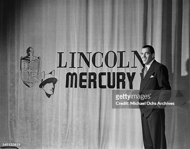 Host Ed Sullivan poses by the Lincoln Mercury sign on the curtain during the "Toast of the Town" show hosted by Ed Sullivan at the Maxine Elliott...