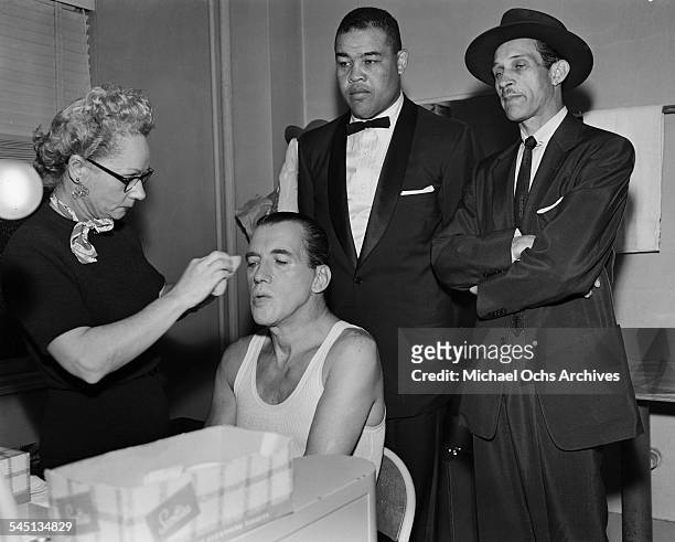 Boxer Joe Louis, producer Leonard Reed watch Ed Sullivan get ready for the "Toast of the Town" show hosted by Ed Sullivan at the Maxine Elliott...