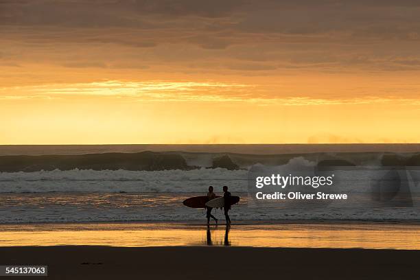 surfers at sunset - waitakere city stock pictures, royalty-free photos & images