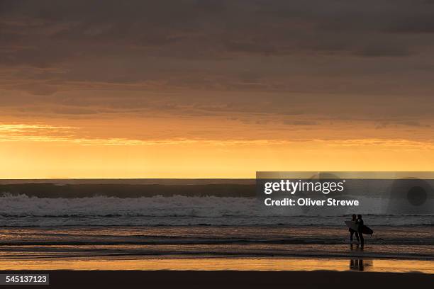 surfers at sunset - waitakere city stock pictures, royalty-free photos & images