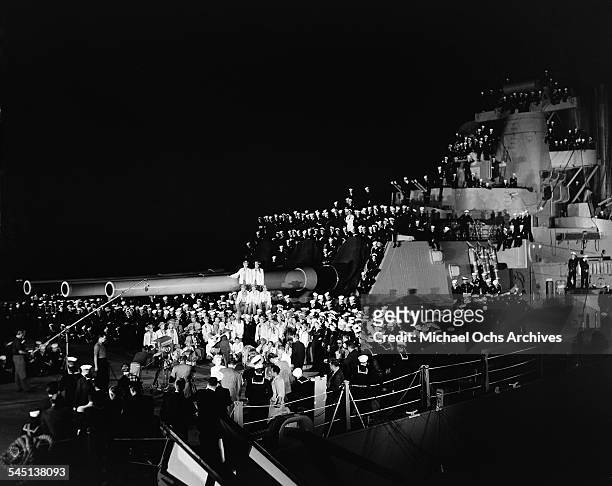 Burl Ives sings on the deck of the USS Wisconsin, docked on the Hudson River during a broadcast of the "Toast of the Town" show hosted by Ed Sullivan...