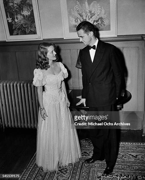Actress Bette Davis talks with Howard Hughes at an event in Los Angeles, California.