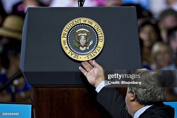 Secret Service agent adjusts the Presidential Seal on a podium during a campaign rally for Hillary Clinton, presumptive 2016 Democratic presidential...