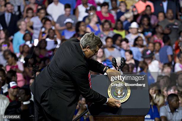 Secret Service agent adjusts the Presidential Seal on a podium during a campaign rally for Hillary Clinton, presumptive 2016 Democratic presidential...