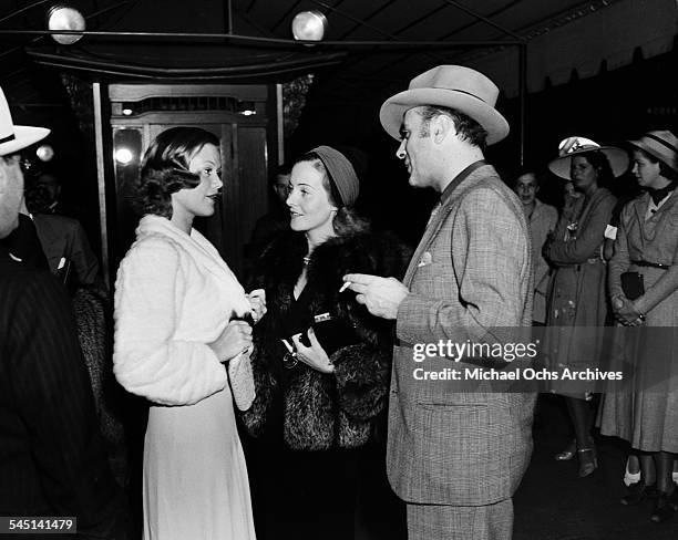 French actor Charles Boyer and wife Pat Paterson talks with French actress Simone Simon at an event in Los Angeles, California.