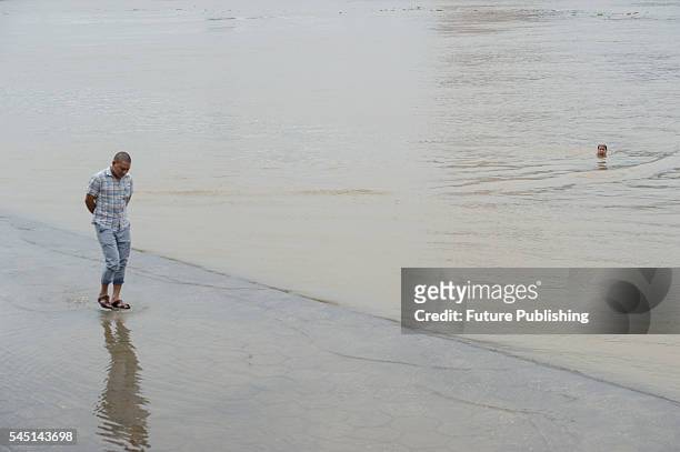 Man walks on the bank of the surging Hanjiang River on July 04, 2016 in Hubei province, China. Heavy rains have caused flooding in provinces in the...
