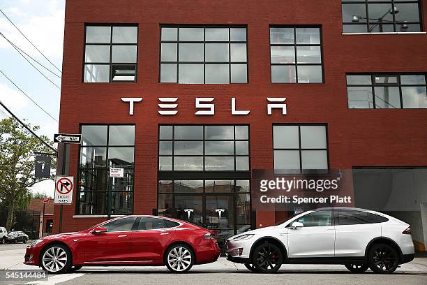 Tesla vehicles sit parked outside of a new Tesla showroom and service center in Red Hook, Brooklyn on July 5, 2016 in New York City. The electric car...