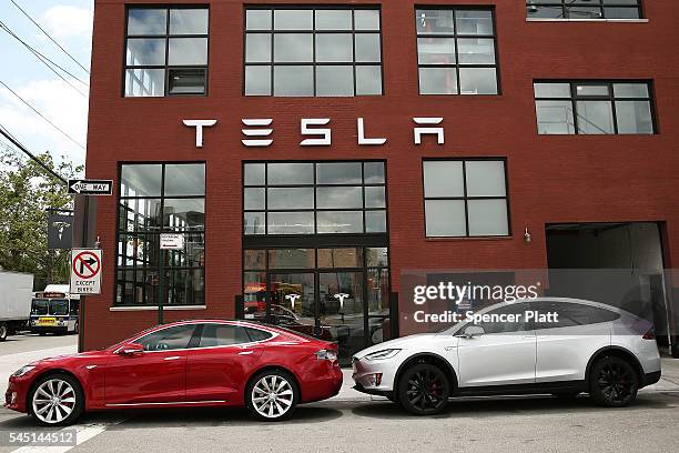 Tesla vehicles sit parked outside of a new Tesla showroom and service center in Red Hook, Brooklyn on July 5, 2016 in New York City. The electric car...