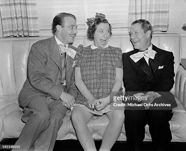 Comedian Fanny Brice sits with friends Joe E. Brown during her birthday party in Los Angeles, California.
