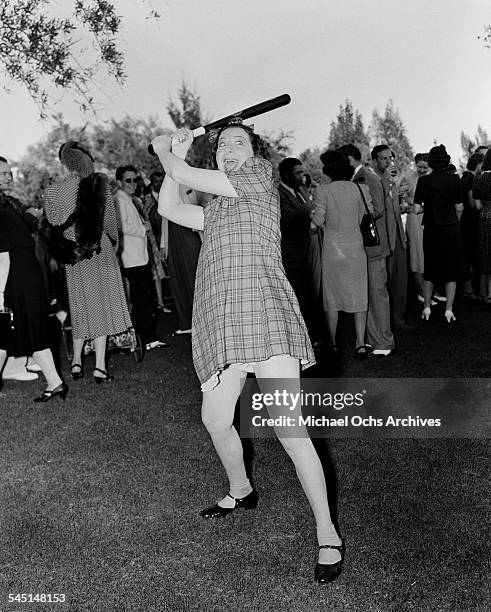 Comedian Fanny Brice poses with bat at her birthday party in Los Angeles, California.