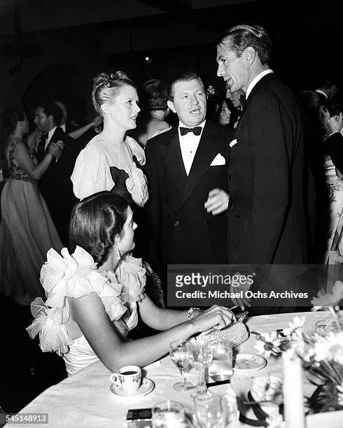 Actor Gary Cooper and wife Veronica Balfe chat with actress Mary Astor at an event in Los Angeles, California.