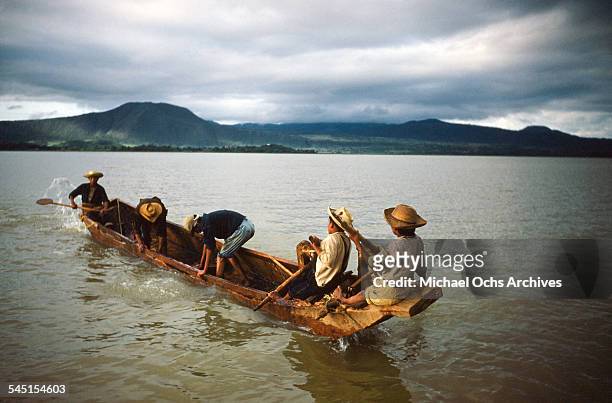 Group of fishermen in a boat pull up a fishing net on the lake in Patzcuaro, Michoacan, Mexico.